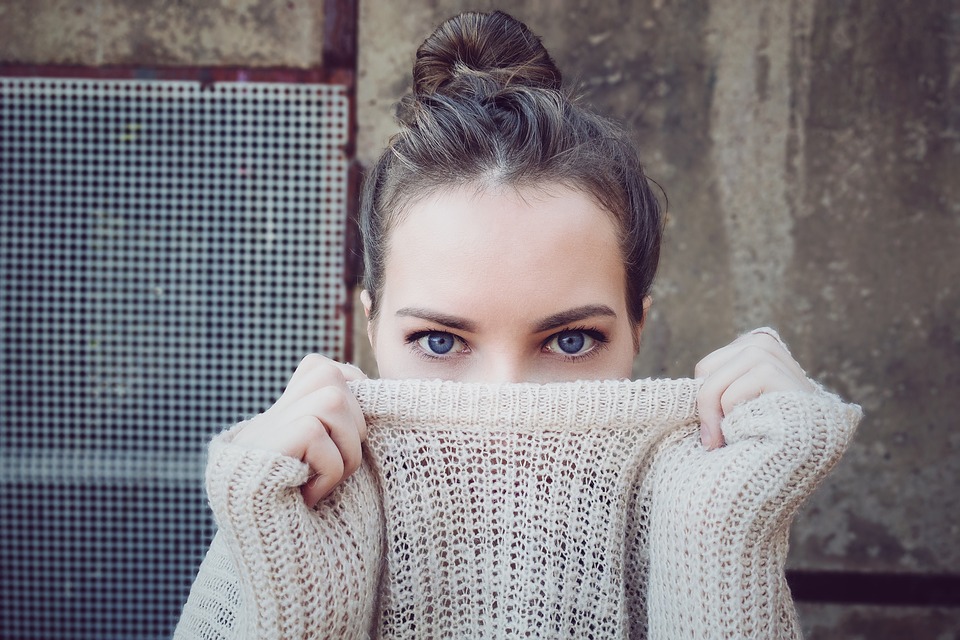 woman with her sweater pulled up high
